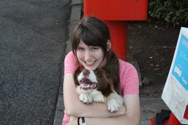 テイラーさんが犬を抱きしめて笑顔で写っている写真です。.