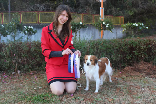犬と女性のドッグショー受賞シーンの写真.