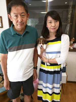 家族と犬が一緒に室内でポーズをとる写真.