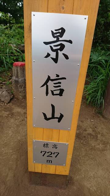 山の景色を示す標識と標高727メートルの表示.