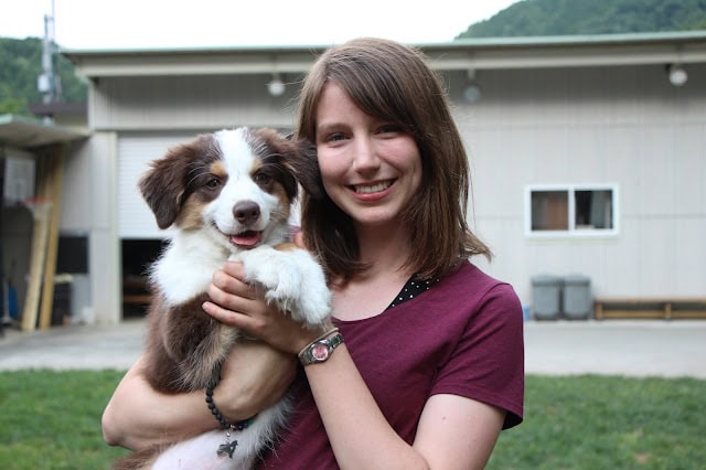 犬を抱く若い女性の笑顔と幸せな表情.