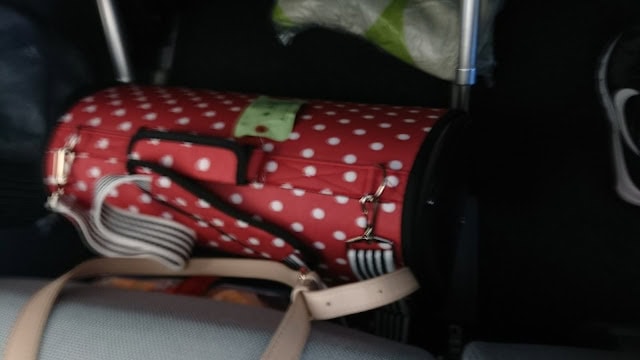 荷物が詰まった赤と白のドット柄のスーツケース.