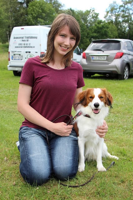 女性と犬が緑の芝生の上に座っています.