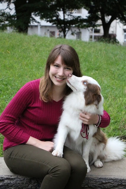 ダイアナとかわいい犬が公園で一緒に座っています。.