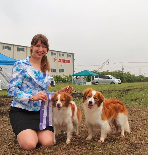 受賞者と2匹の犬が屋外でポーズをとるシーン.