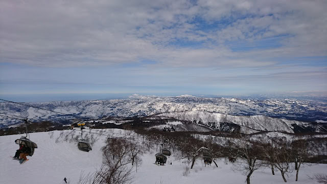 雪山とリフトに乗るスキーヤーの風景.