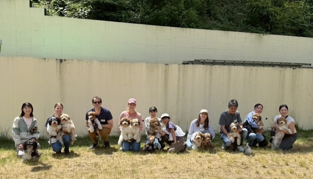 犬と一緒に屋外でグループ写真を撮る人々の集合写真.